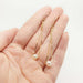 Hand holding 14kt yellow gold teardrop earrings with freshwater pearls