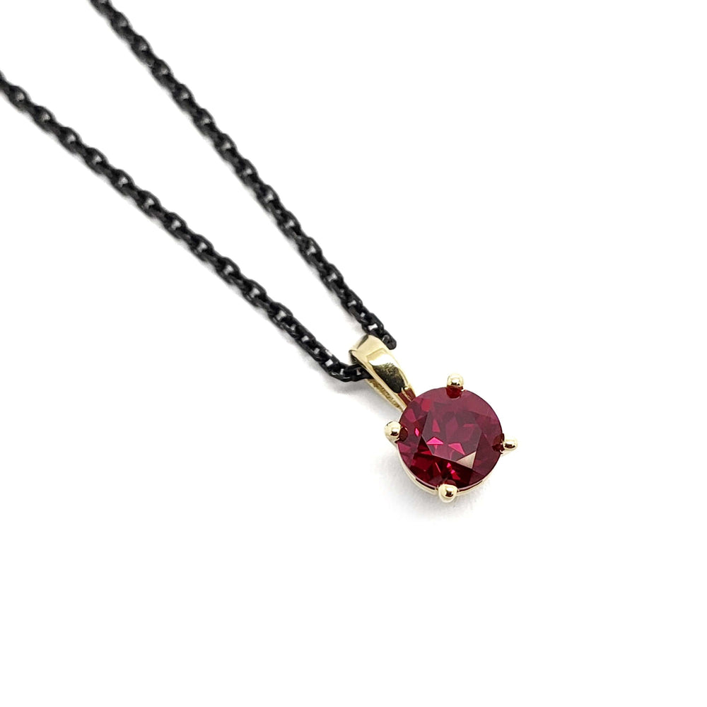 14kt yellow gold pendant with round lab-grown ruby on a black chain
