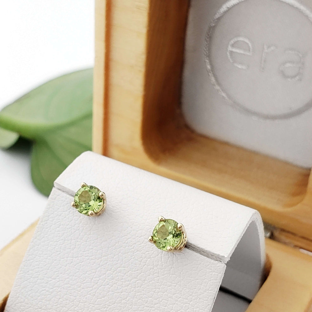 14kt yellow gold peridot stud earrings displayed in a wooden jewellery box