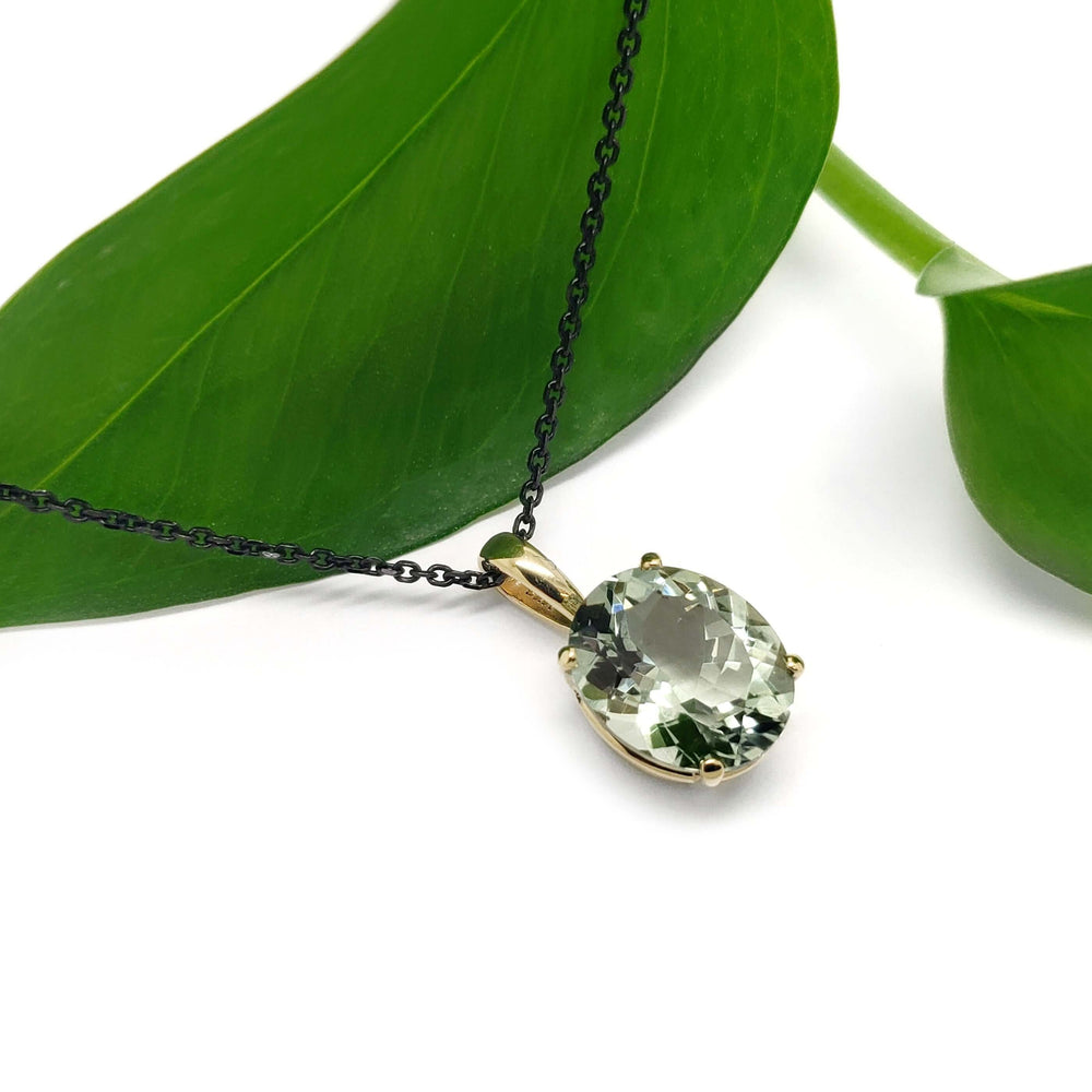 14kt yellow gold prasiolite pendant on black chain, styled with green leaf