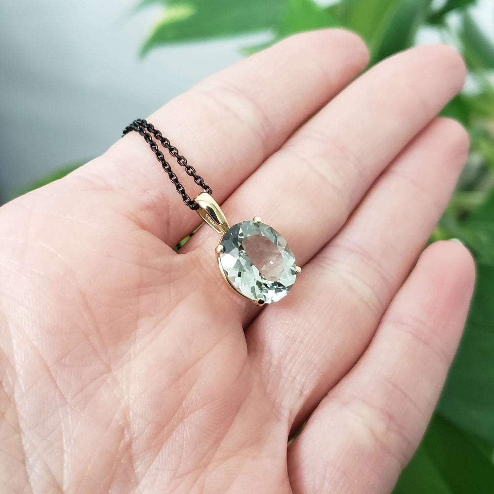 14kt yellow gold prasiolite pendant with soft green gemstone shown in hand