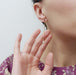 Model wearing a 14kt yellow gold dangle earring with seed pearls