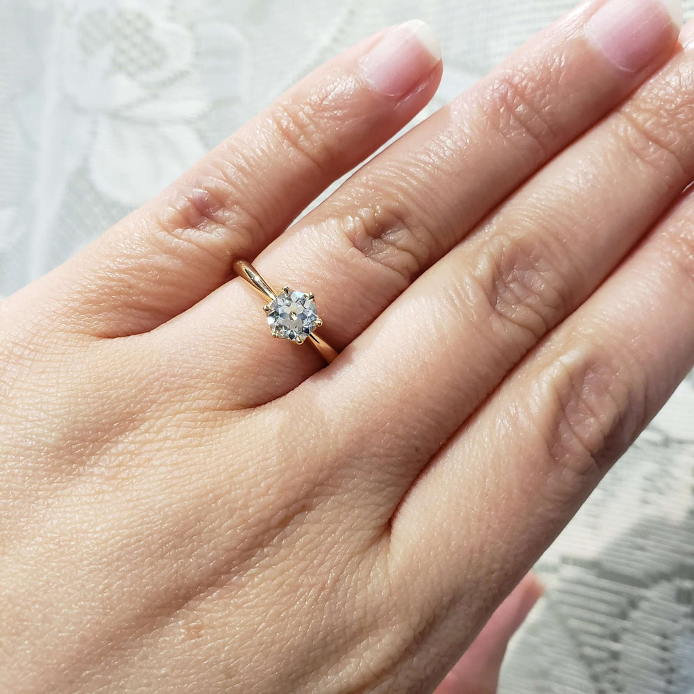 14kt yellow gold solitaire diamond ring shown on a hand