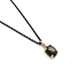 14kt yellow gold pendant with oval black star sapphire on a black chain, angled view