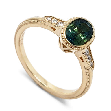 14kt yellow gold ring with oval teal Australian sapphire and Canadian diamond accents, millgrain detail