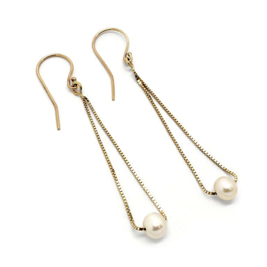 Pair of teardrop earrings in 14kt yellow gold with freshwater pearls on white background