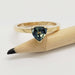 14kt yellow gold ring with trillion teal Australian sapphire, shown with pencil for scale
