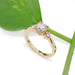 14kt yellow gold vintage diamond engagement ring beside a green leaf, angled view