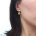 Vintage lotus earring in 14kt yellow gold with blue topaz shown worn on ear