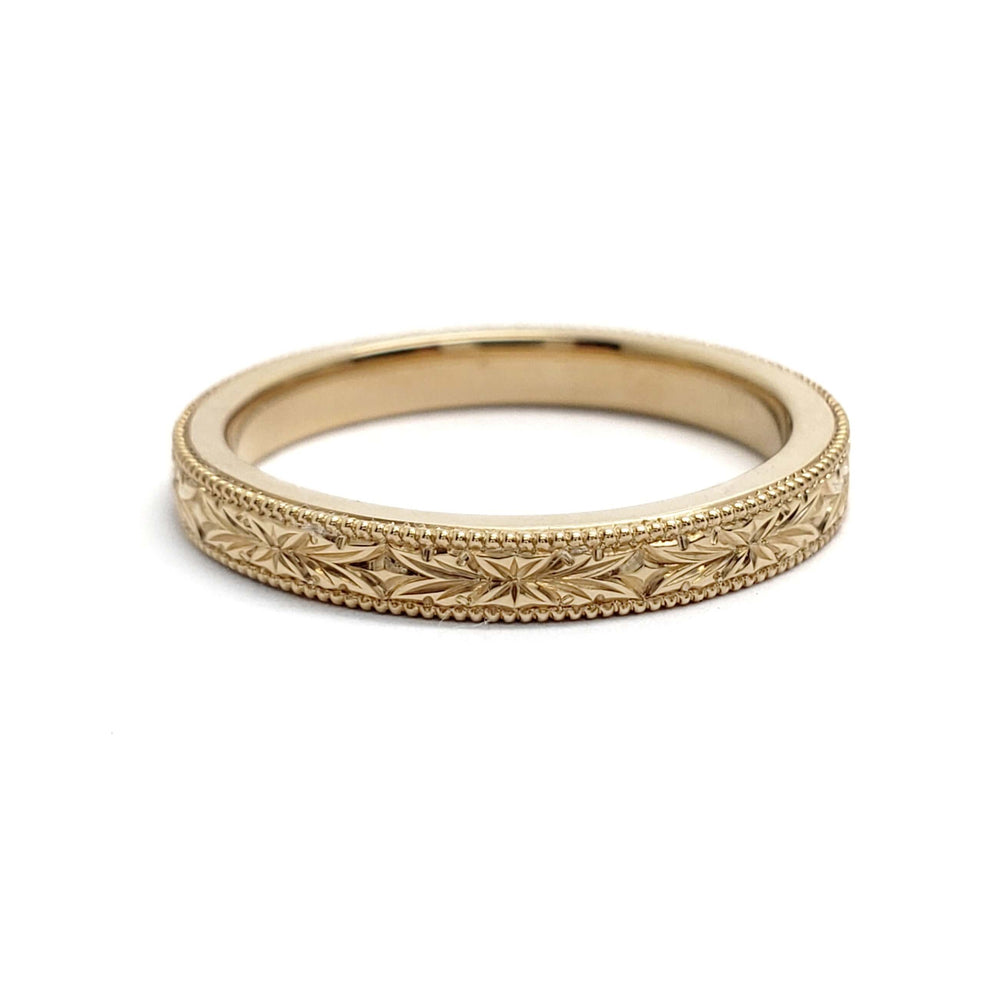 14kt yellow gold wedding ring with engraved floral pattern and millgrain border
