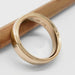 14kt yellow gold wedding ring with millgrain detail, angled view on a pencil