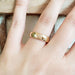 14kt yellow gold wedding ring with millgrain edge shown on a hand