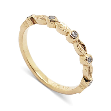 14kt yellow gold wedding ring with textured leaf details and bezel set diamonds