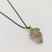 A clear quartz acorn pendant necklace with a gold cap and a black cord, shown on a plain light gray background.