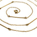 A gold chain necklace with a minimalist design, featuring alternating sections of a fine curb chain and polished bar links, coiled on a white background.