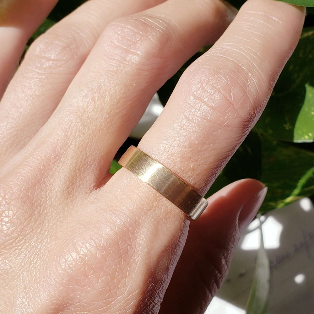 5mm brushed rose gold wedding ring worn on hand in natural light