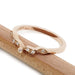 Angled view of 14k rose gold leaf wedding ring with Canadian diamonds on wood