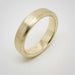 Angled view of 14k yellow gold brushed wedding band on white background