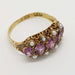 Angled view of antique 15kt yellow gold ring with purple fluorite and pearls