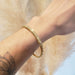 Antique 15kt yellow gold and seed pearl bangle worn on wrist