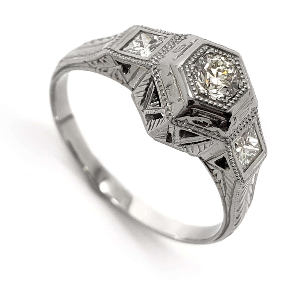Antique 18kt white gold ring with hexagon-set round diamond and princess cut side diamonds