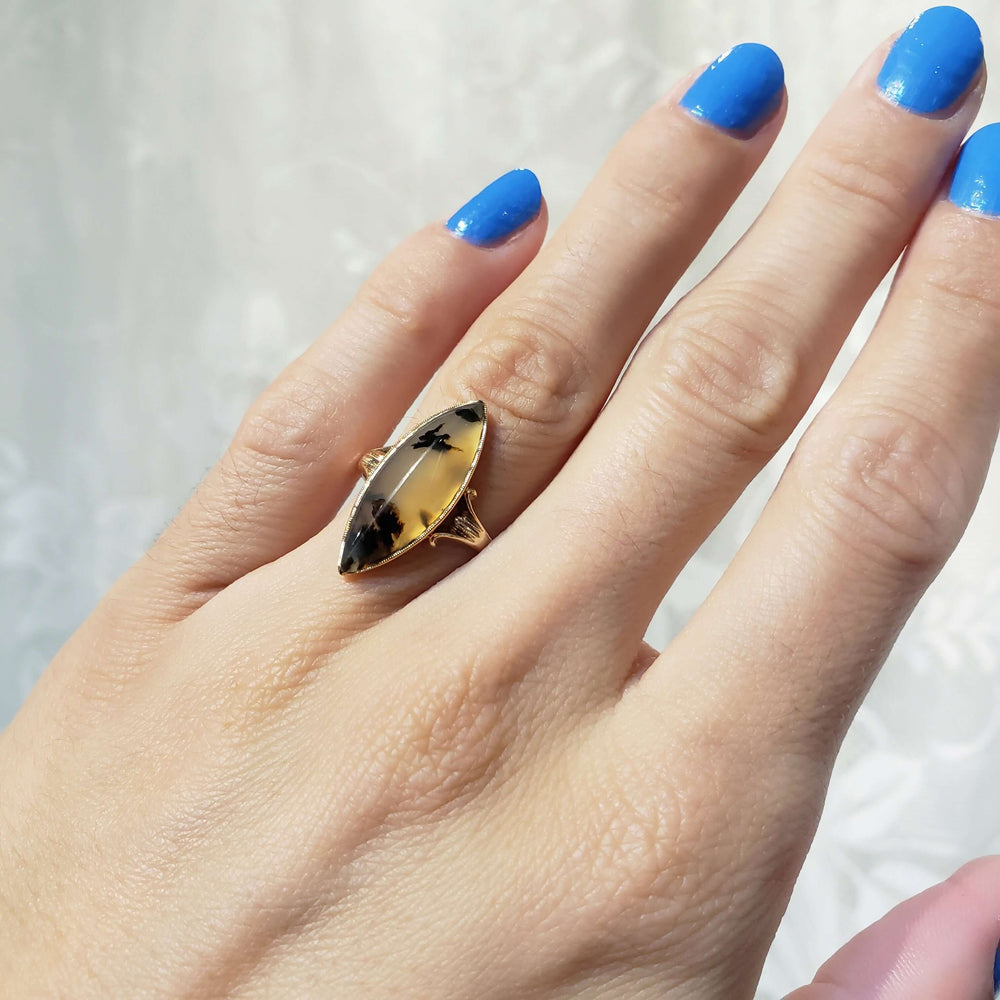 Antique marquise dendritic agate ring in yellow gold, shown on a hand for scale