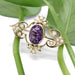 Antique amethyst and seed pearl brooch in yellow gold displayed on green leaves
