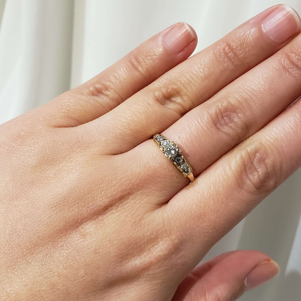 Antique diamond ring in yellow and white gold shown on hand