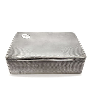 Antique rectangular silver cigar box with textured finish and monogrammed medallion on lid
