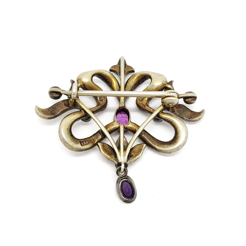 Back view of antique silver brooch showing amethyst settings and pin mechanism