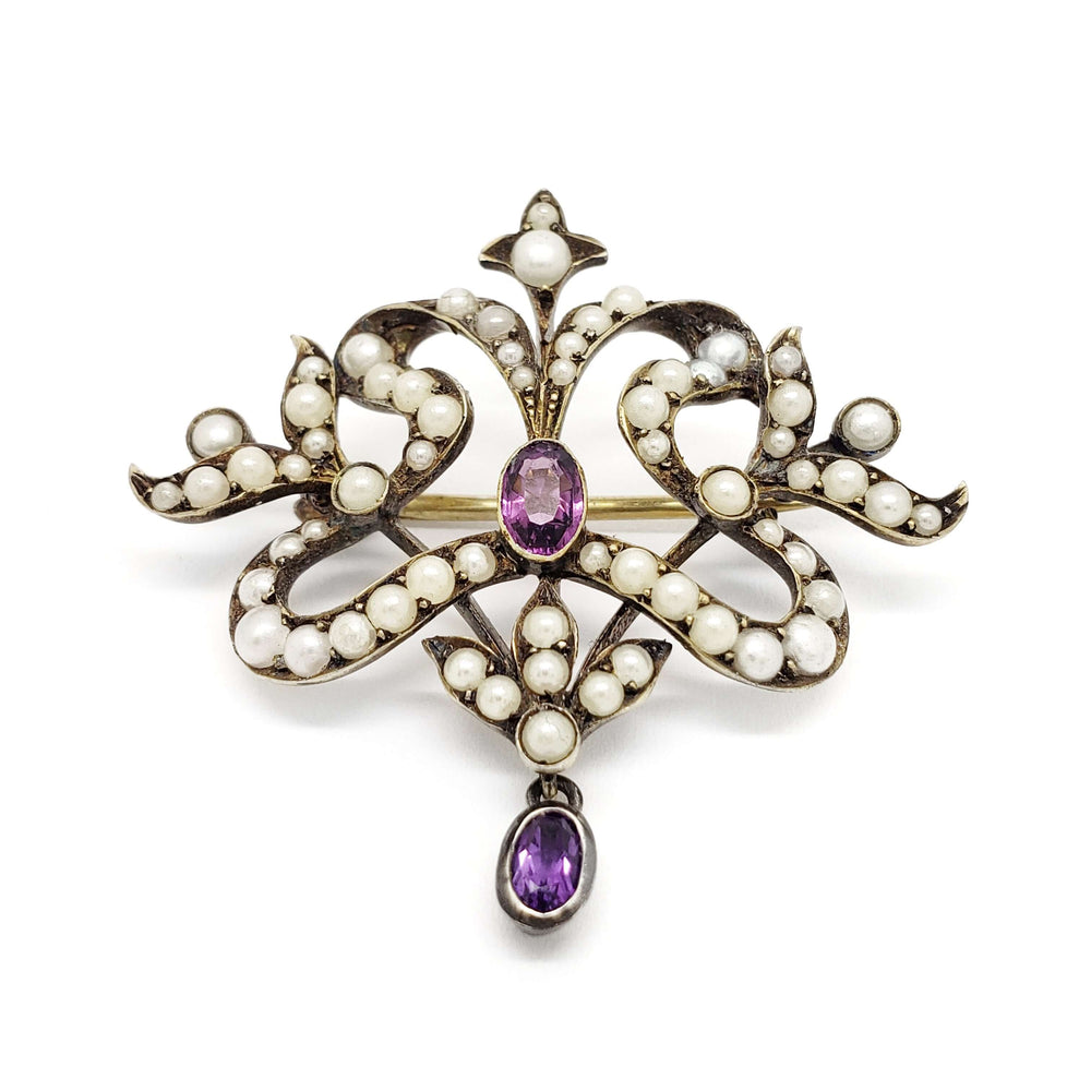 Front view of antique silver brooch with pearls and two oval amethysts