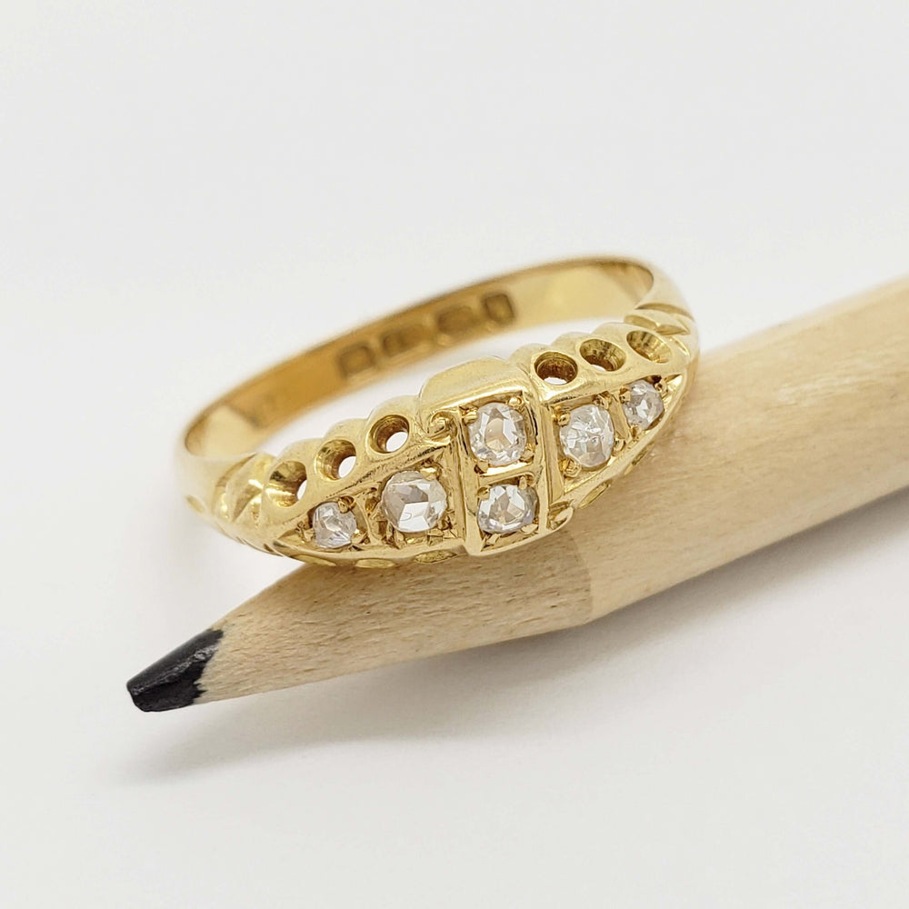 Antique six stone diamond ring in 18kt yellow gold displayed on pencil