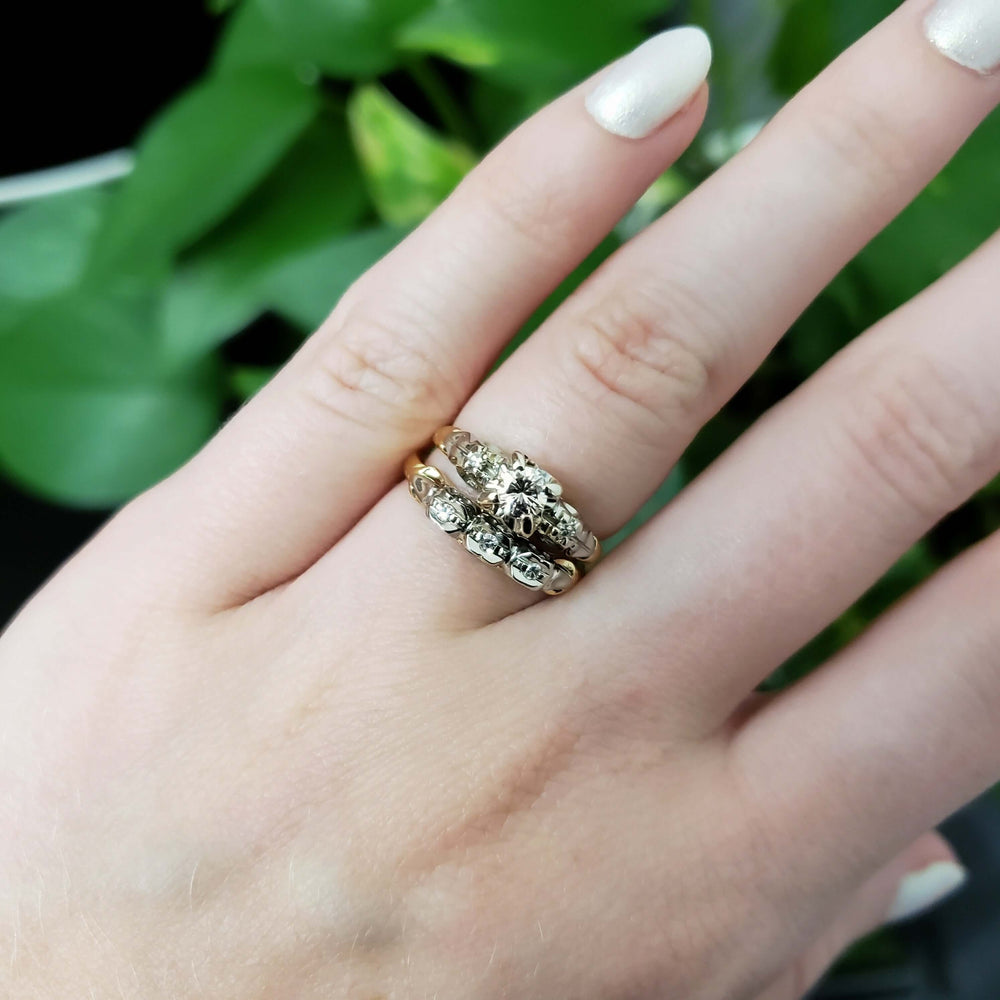 Antique two-tone diamond engagement ring stacked with matching wedding band on a hand