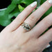 Antique two-tone diamond engagement ring stacked with matching wedding band on a hand