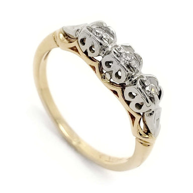 Antique two-tone wedding ring with three round diamonds in white gold settings on a yellow gold band