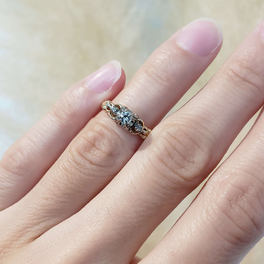 Antique diamond ring in yellow and white gold shown on hand