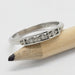 Art Deco style 14kt white gold ring with three Canadian diamonds, shown on a pencil