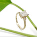 Art Deco inspired yellow gold engagement ring with lab diamond, shown with green leaf