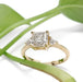 Asscher cut lab diamond engagement ring in yellow gold with side diamonds, styled with greenery