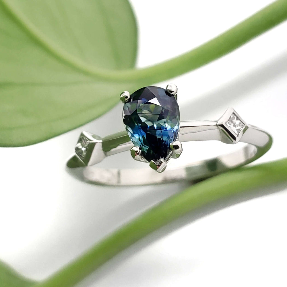 Australian sapphire and diamond engagement ring in white gold, shown with green leaf