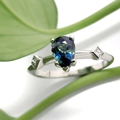 Australian sapphire and diamond engagement ring in white gold, shown with green leaf
