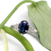 Australian sapphire and diamond engagement ring in white gold, displayed with green leaf