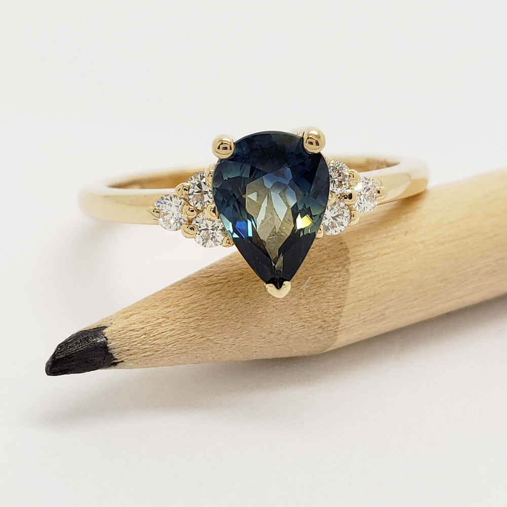 Australian sapphire and diamond engagement ring in yellow gold, displayed on a pencil