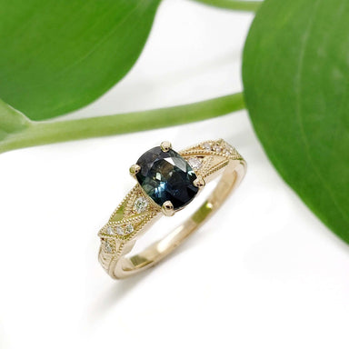 Australian sapphire and diamond engagement ring in yellow gold, shown with green leaves