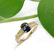Australian sapphire and diamond engagement ring in yellow gold, shown with green leaves