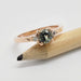 Australian sapphire and diamond rose gold ring resting on a pencil