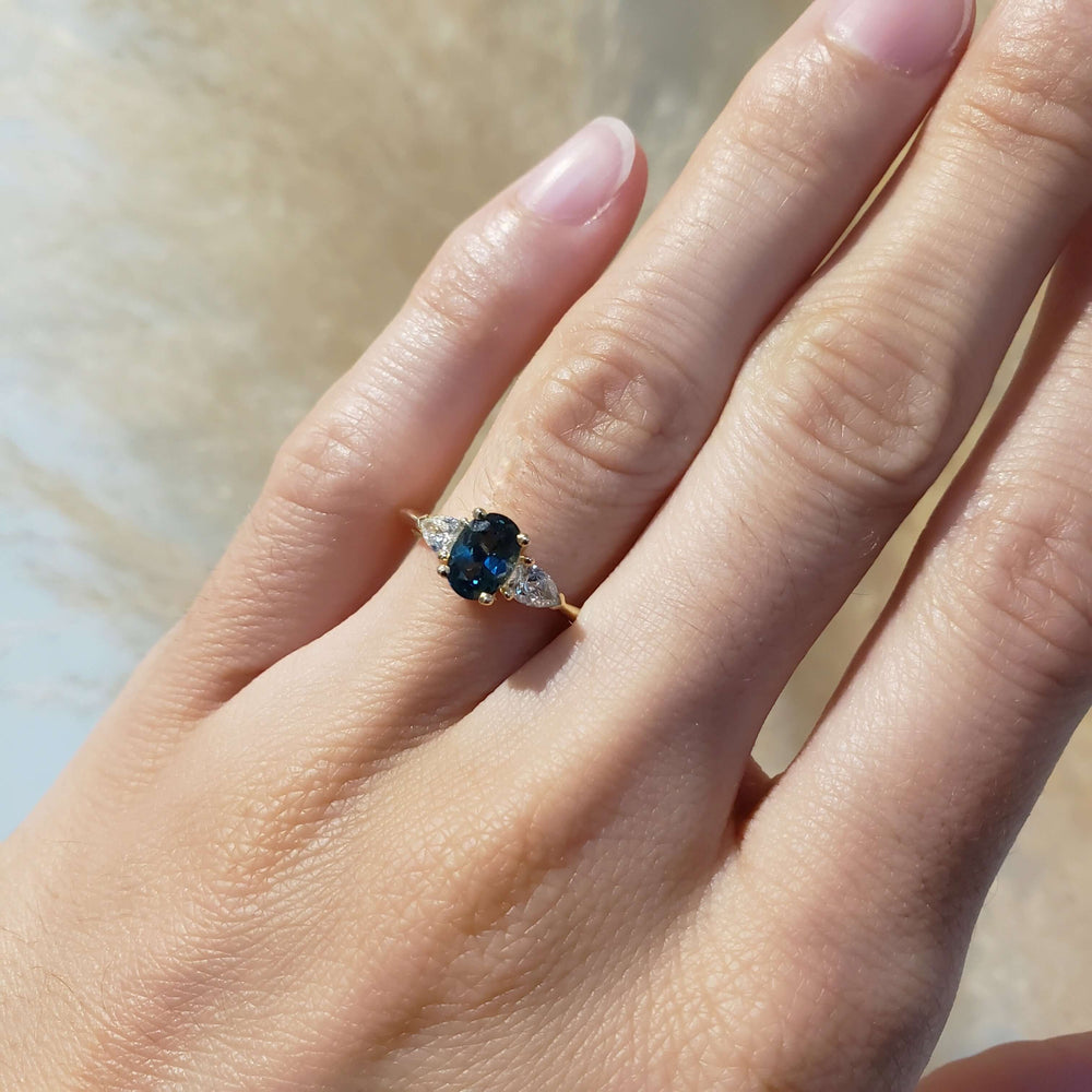 14kt yellow gold sapphire and lab diamond ring shown on hand in natural light