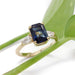 Australian sapphire and lab diamond engagement ring in yellow gold, shown with green leaves