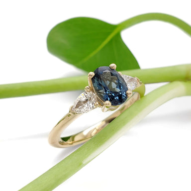 14kt yellow gold ring with blue sapphire and lab diamond side stones on green stem