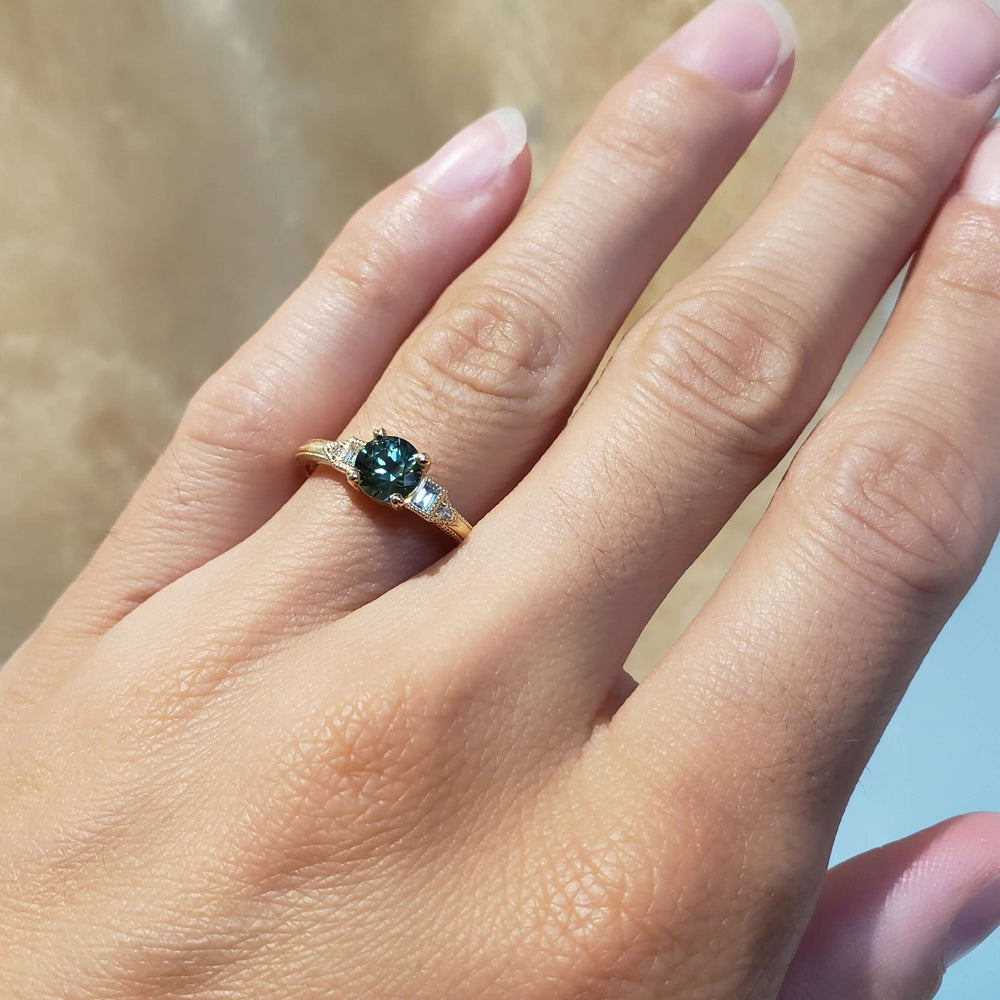 Australian sapphire and lab diamond yellow gold ring shown on a hand